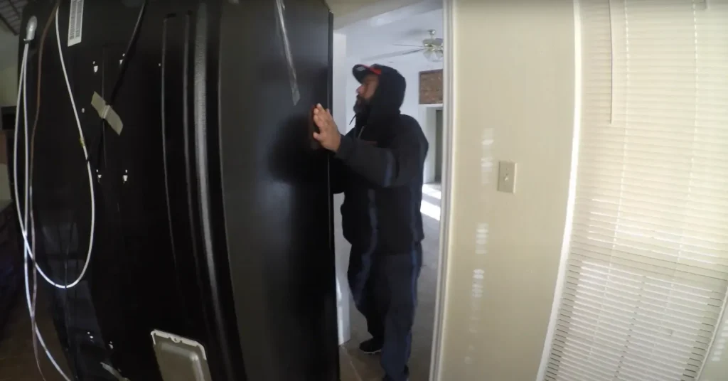 Local Movers 15 Mover steadying a tall black appliance in a hallway